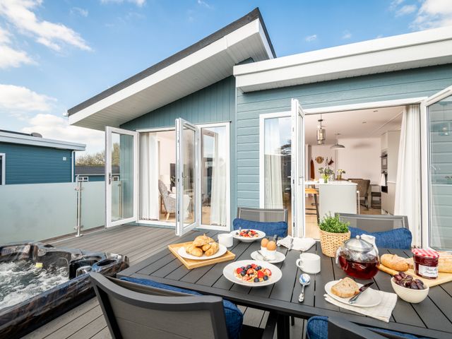 A table set with food and drinks on an outdoor terrace at Sennen 2 Spa Roof Terrace (Pet) Bude