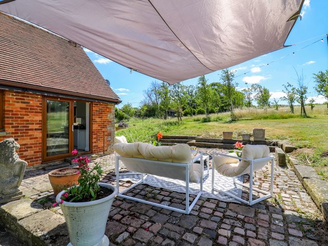 An outdoor seating area with a sofa and table at Barn Owl Cottage in Carlton near Harrold