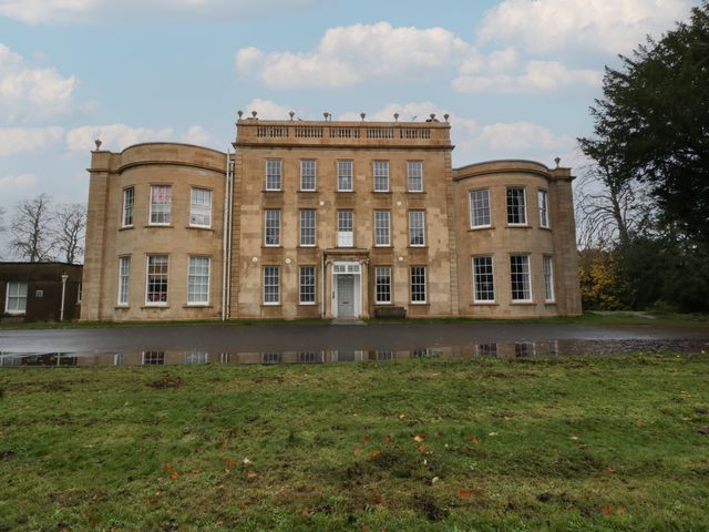 A building with windows and a door in front of grass at Frenchay Park House in Bristol