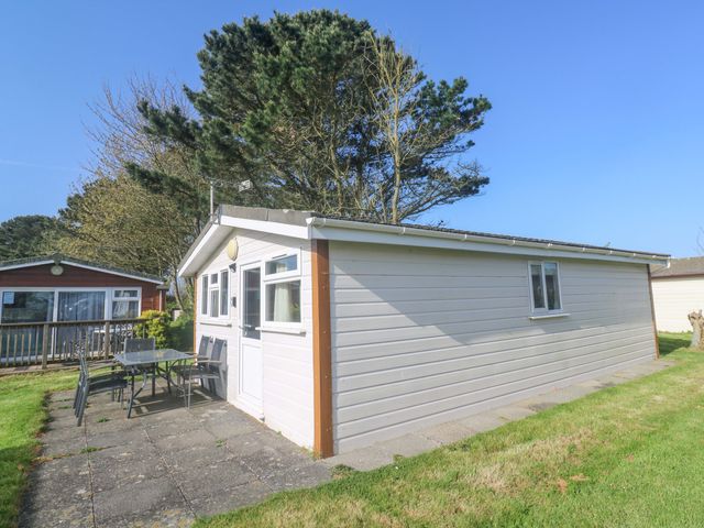 An outdoor area with a chalet and patio furniture at Chalet 225 Tregolds near St Merryn