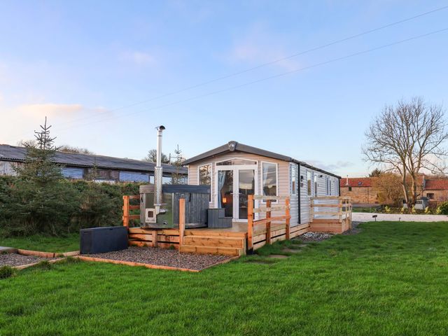 A cabin with a deck and stove at Swift Cabin Scarborough