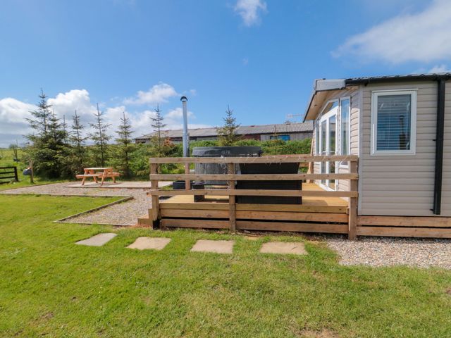 An outdoor area with a hot tub and picnic table at Swift Cabin in Staintondale near Scarborough