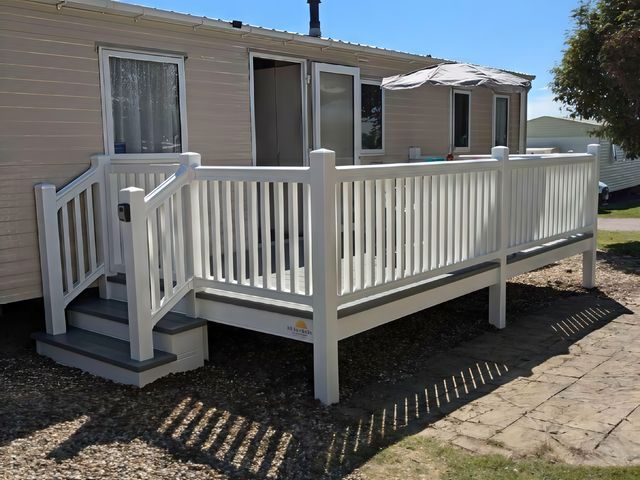 An outdoor decking area with a railing and steps at Coopers Beach Holiday Park - Holiday Accommodation 6404 Mersea Island