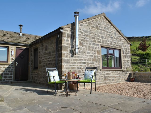 An outdoor area with chairs and a table at Baywood Cottage in Keighley