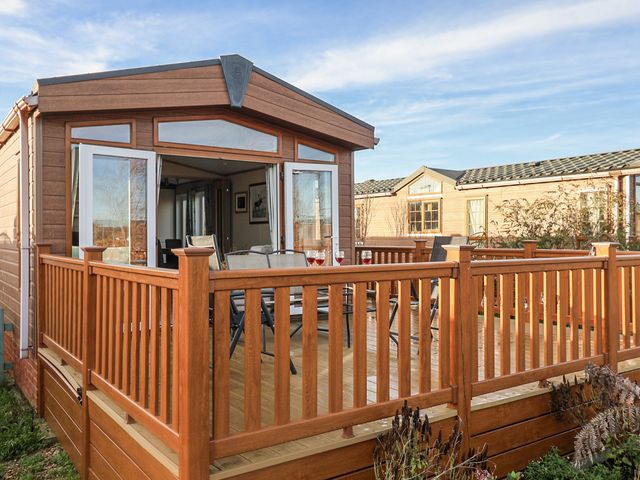 An outdoor space with decking and chairs at Fern Lodge in Stonham Aspal