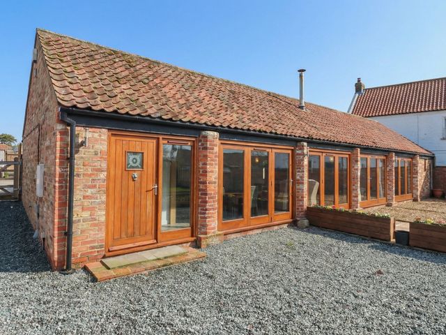 An outdoor area with a brick building and wooden features at Pillar Barn Driffield