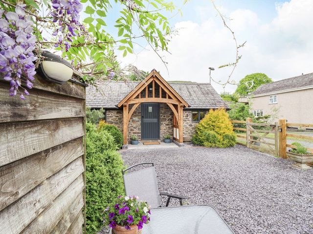 A house with a gravel driveway and garden at The Talkhouse Cottage in Caersws