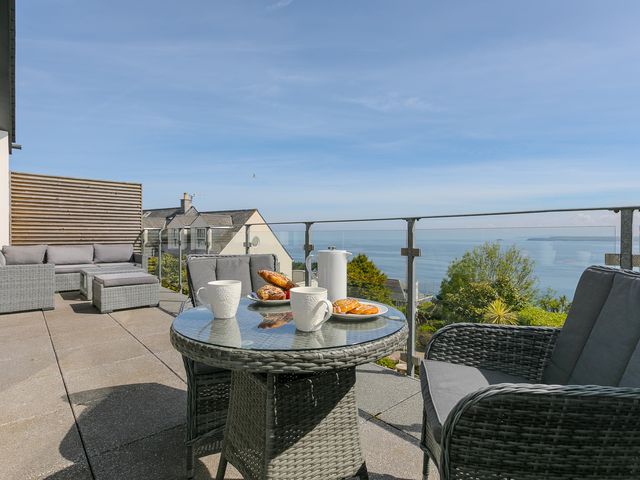 An outdoor seating area with a table and chairs at 2 Remera in St Ives