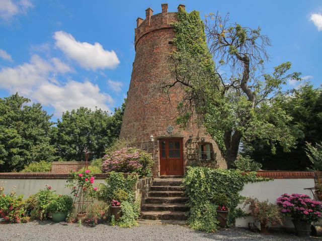 A historic tower with plants and a door at Hadley Park Windmill near Telford