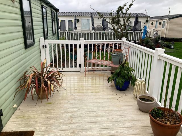 An outdoor area with planters and a seating bench at Beachside in Towyn