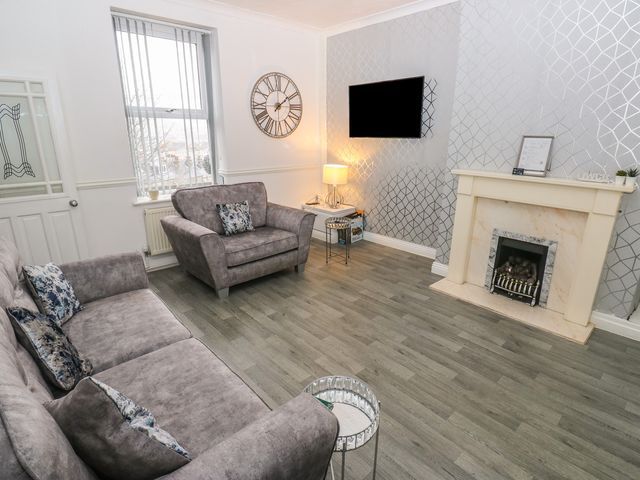 A living room with a sofa and armchair at Chestnut Lodge in Bradford