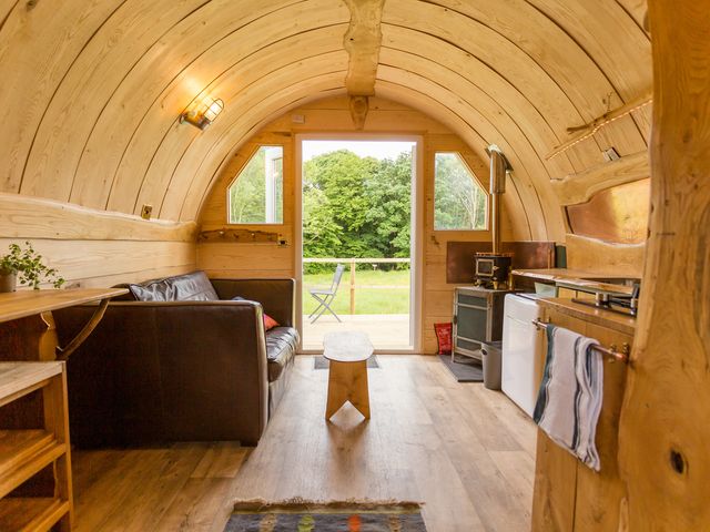 A living room with a couch and kitchen unit at Glamping pod-Luxury Glamping Retreat in Battle