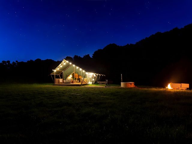 A tent with lights and a fire pit at Badger - Luxury Glamping Retreat in Battle