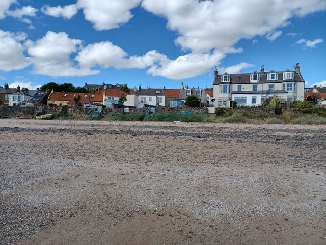 A beach with houses in the background at Beach Haven 116 Leven