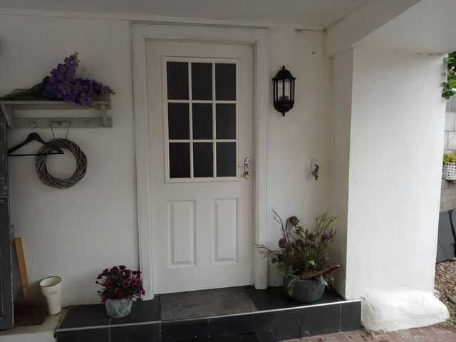 An entrance with a door and flower arrangements at 14 Largo Road in Leven