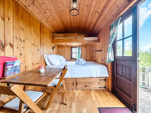 A bedroom with a bed and table at Bryn Mawr Cabin in Clun