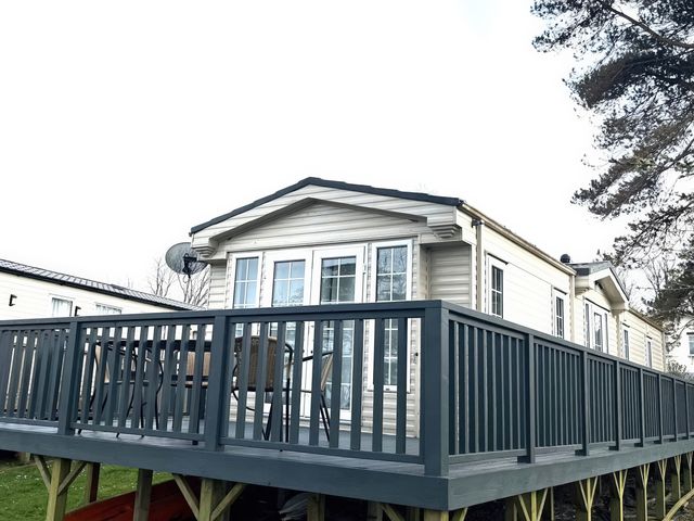 A caravan with decking and table at Caravan 38 Newport