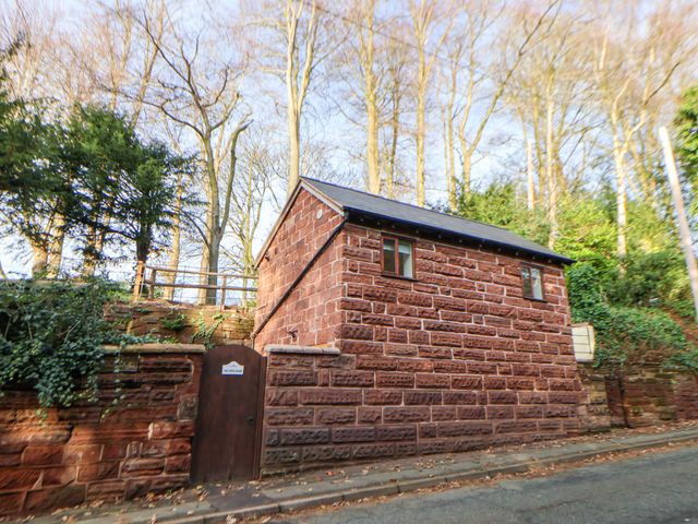 A stone building with a window and door beside trees at The Apple Store in Tarporley