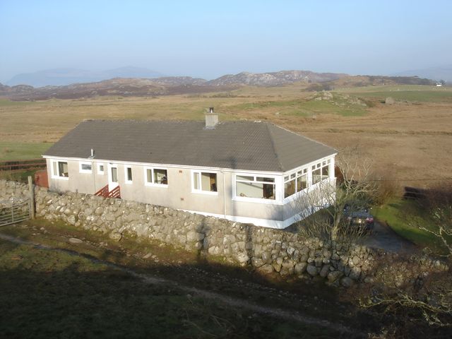 A house with stone wall and car in front at Erisgeir Isle of Mull
