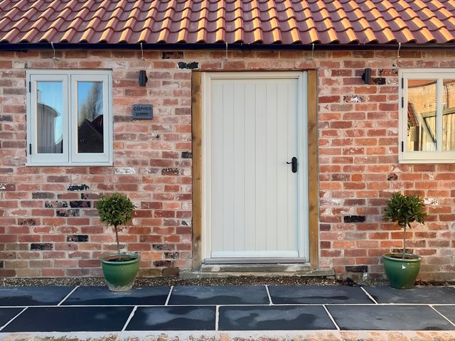 An entrance with a door and windows at Coach Lodge in Retford