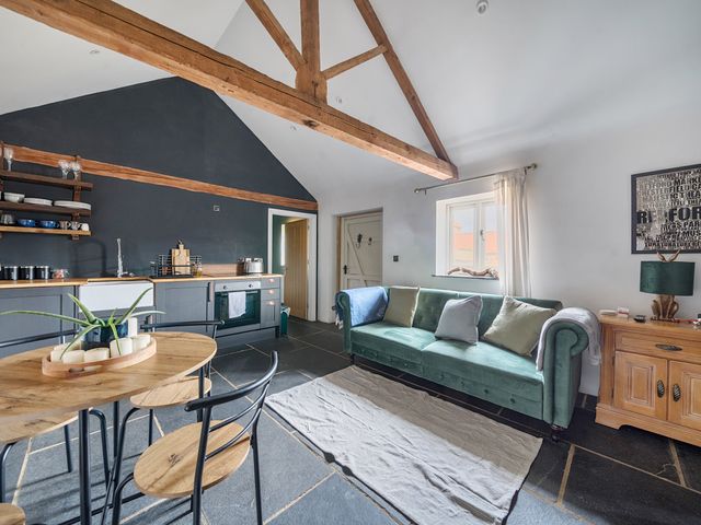 A living room with a sofa and dining area at Coach Lodge in Retford