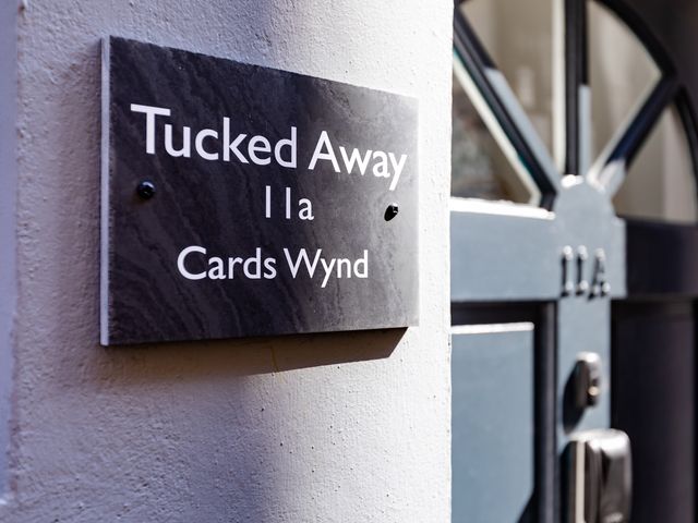 A nameplate on a wall next to a door at 11A Cards Wynd Anstruther
