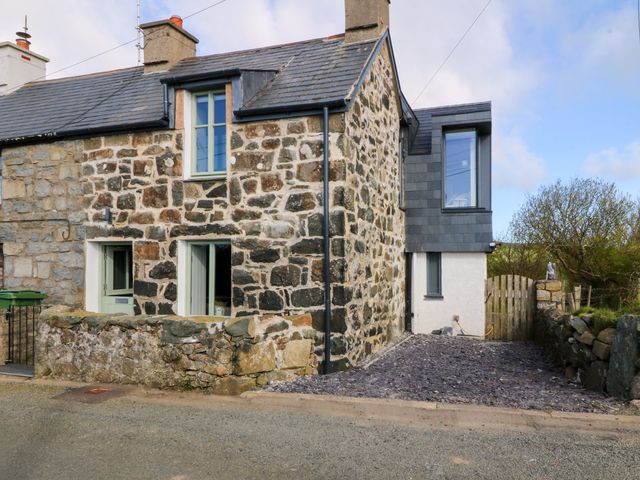 A stone house with a slate roof and a gravel driveway at Seren Fach in Pwllheli