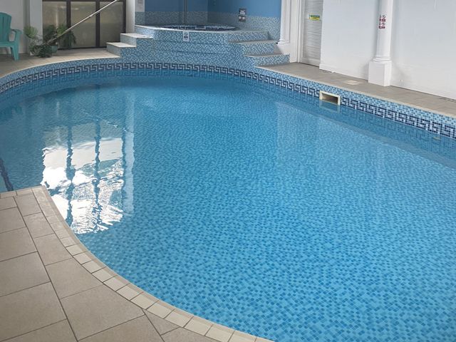 A swimming pool with tiled edges at Honeypot Cottage in Whitchurch Canonicorum