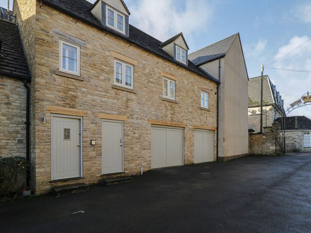 An exterior view of a house with garage doors and windows at Flat 6