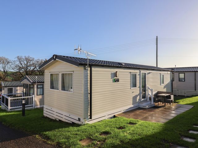 A mobile home with a patio and furniture at Jurassic Discovery in Charmouth