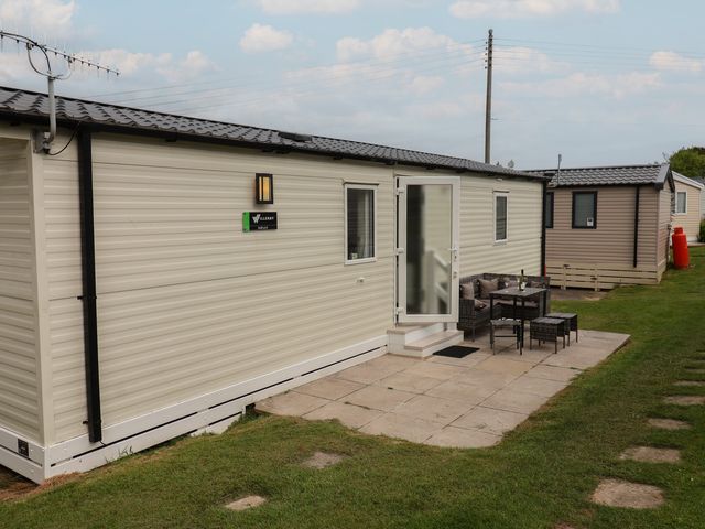 A mobile home with patio furniture at Jurassic Discovery in Charmouth