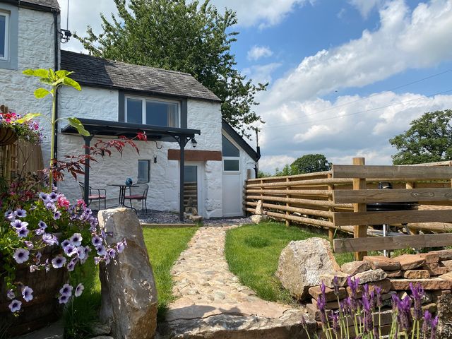 An outdoor area with a stone path and flowers at The Haven in Penrith