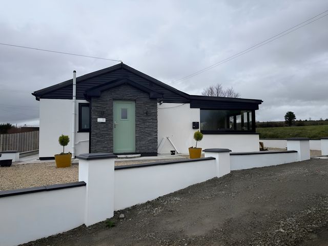 A house with a green door and window at Cherry Chirp Cottage Enniskillen