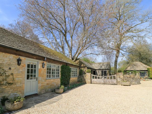 An exterior view of a property with trees and gravel driveway at Foxhill Farm Barn in Cheltenham