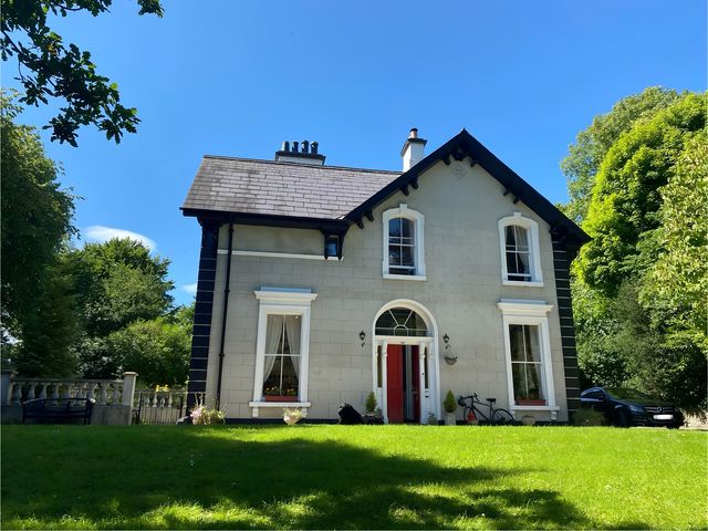 A house with a red door and bicycle at Fountain Hill House in Londonderry