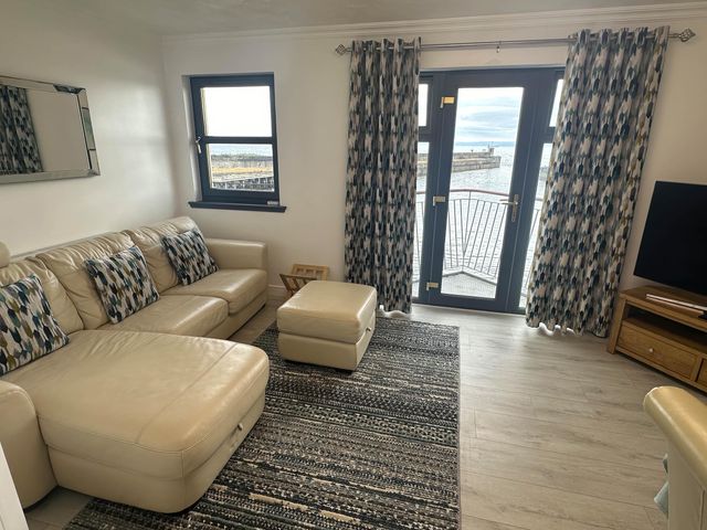 A living room with a sofa and a TV at 36 Deas Wharf Kirkcaldy