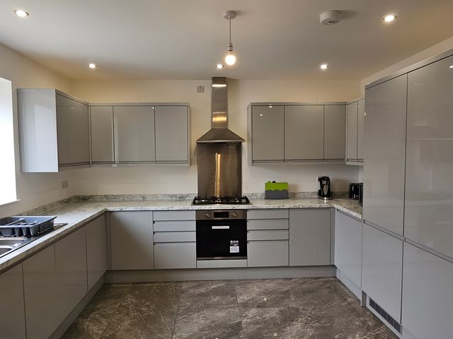 A kitchen with cabinets and appliances at Citrine Suite in Stoke-on-Trent