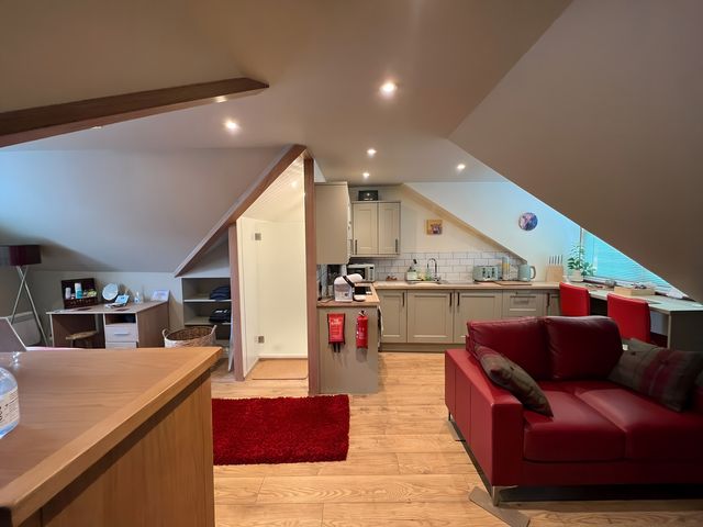 A kitchen and living area with a sofa and dining table at 1 Bed Studio in Pitlochry