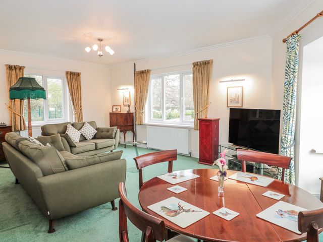 A living room with a sofa, table and television at The Flat House in Taunton