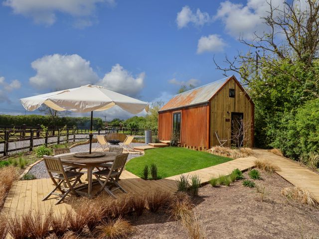 An outdoor area with a table and chairs at Shades Farm Shepherds Hut (Sleeps 4) Circenester