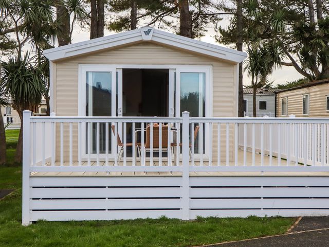 A holiday home with a deck and chairs at Caravan A10 at Landscove Holiday Park Brixham