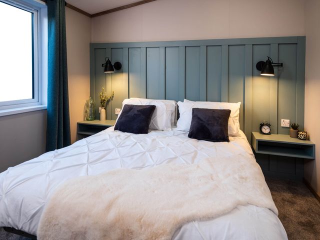 A bedroom with a bed and bedside tables at No 10 Linmere Lodge Escape in Northwich