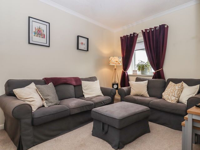 A living room with a sofa and lamp at Petitor Mews