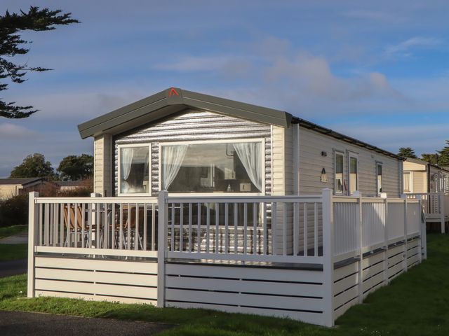 A caravan with a deck and seating area at Caravan B61 at Landscove Holiday Park in Brixham