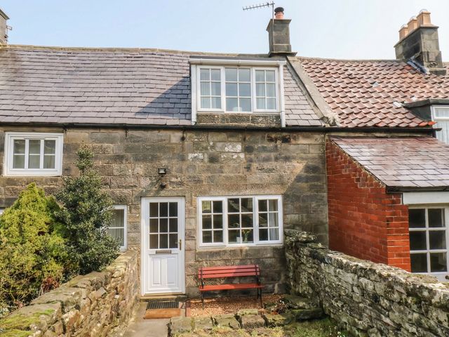 A cottage exterior with a garden and stone wall at 4 Lilac Cottages
