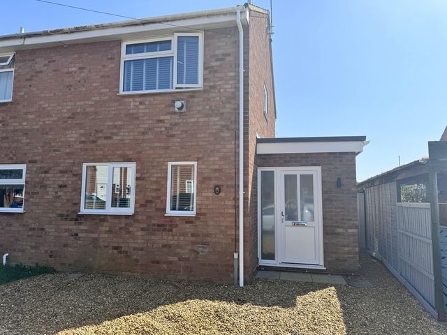 An exterior view of a house with windows and a door at 22 Sandringham Drive in King's Lynn