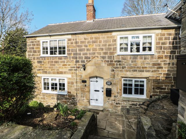 The exterior of a stone house with a garden at Lake Side Cottage in Wakefield