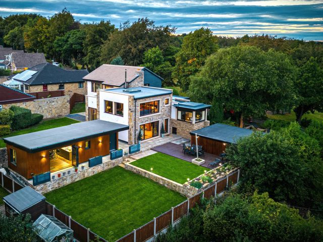 An outdoor view of a modern house and garden at The Luxury Shed in Huddersfield