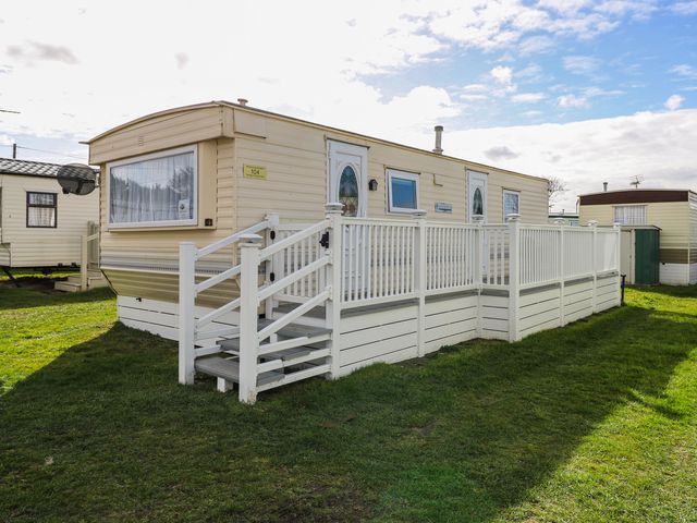 A mobile home with steps and a fence at Whispering Meadows - 104 Hemsby