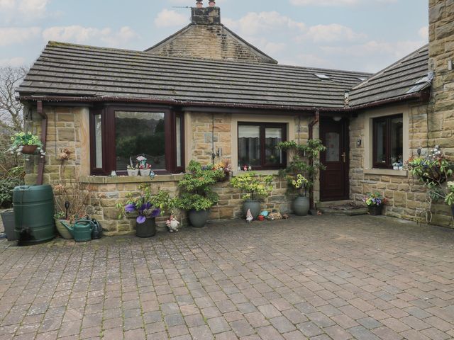 An outdoor view of a house with planters and a water barrel at The Annex at Ryefield Lodge